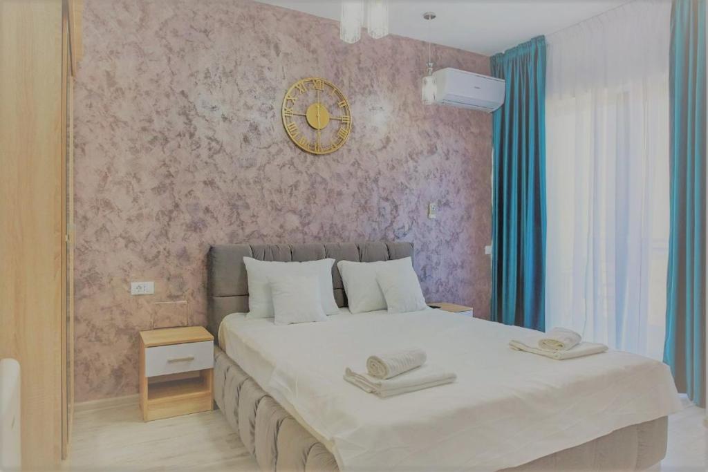 1 dormitorio con 1 cama grande y reloj en la pared en Studio Eli Tomis Villa Mamaia Nord - Năvodari, en Mamaia Nord – Năvodari