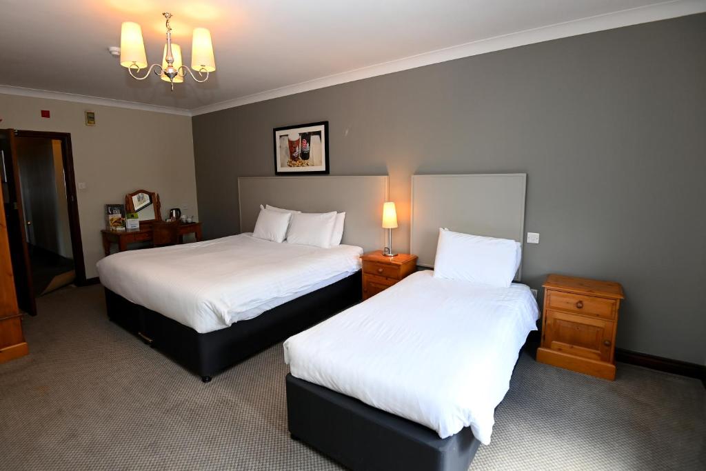 a hotel room with two beds with white sheets at Admiral's Table, Bridgwater by Marston's Inns in Bridgwater
