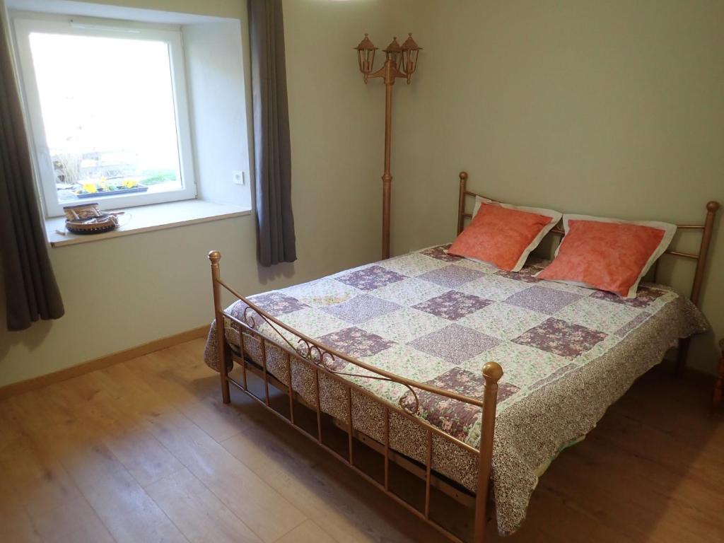 um quarto com uma cama com um cobertor xadrez e uma janela em Gîte le creux de vennes 