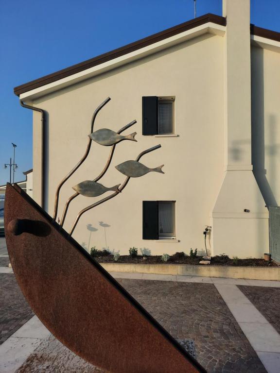 a sculpture in front of a building with birds on it at Borgo Levante Camere in Porto Viro