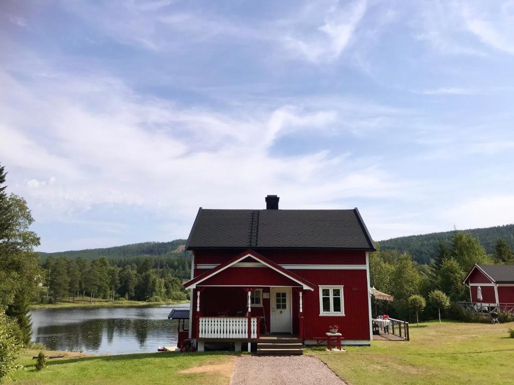 a red house on the side of a lake at Mysigt fritidshus och annex med eget sjöläge! in Torsby