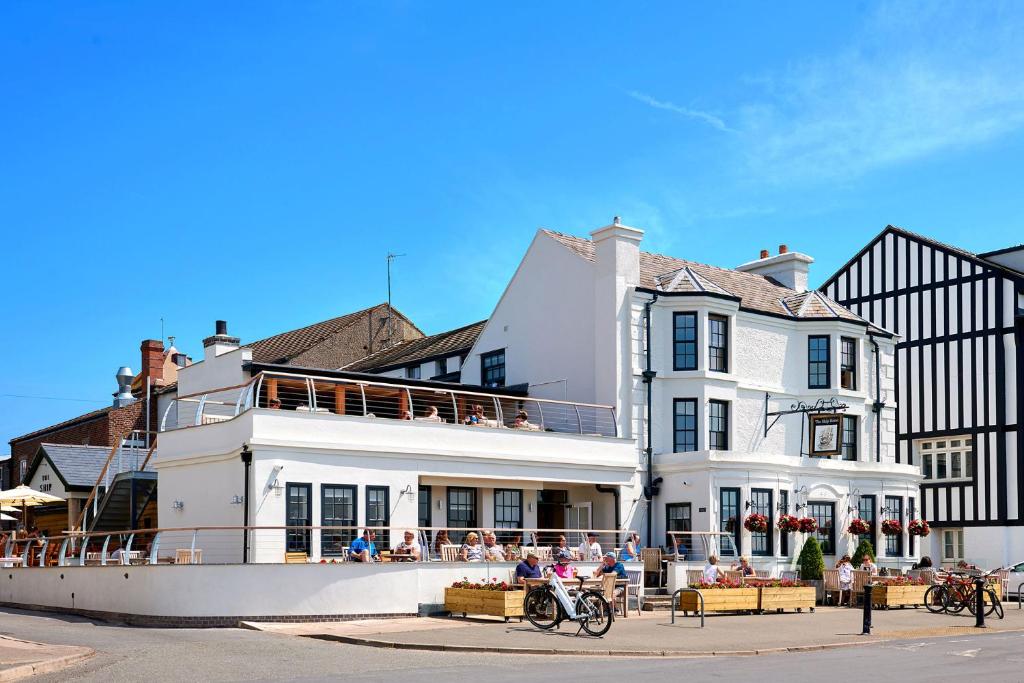 un gran edificio blanco con gente sentada fuera de él en The Ship en Parkgate