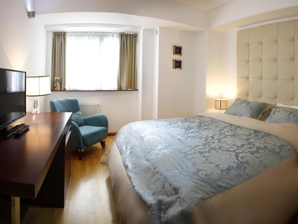 1 dormitorio con cama, escritorio y escritorio en Garden Spa Boutique Hotel, en Skopje