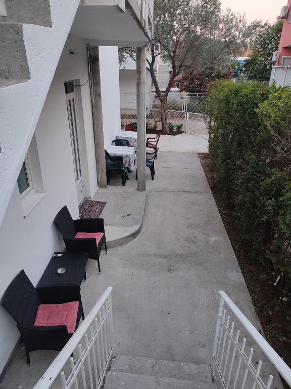 a patio with black chairs and a table on a building at Pejovic Guest House in Sutomore