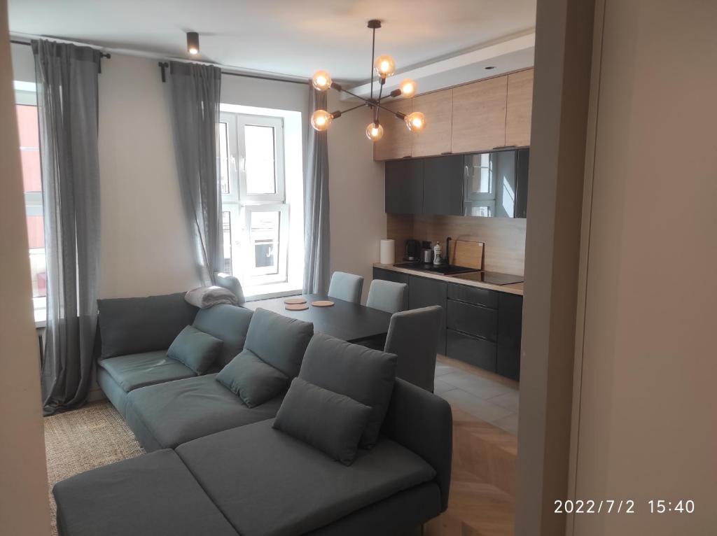 een woonkamer met een bank en een keuken bij Apartament Św. Ducha 29-31 in Gdańsk