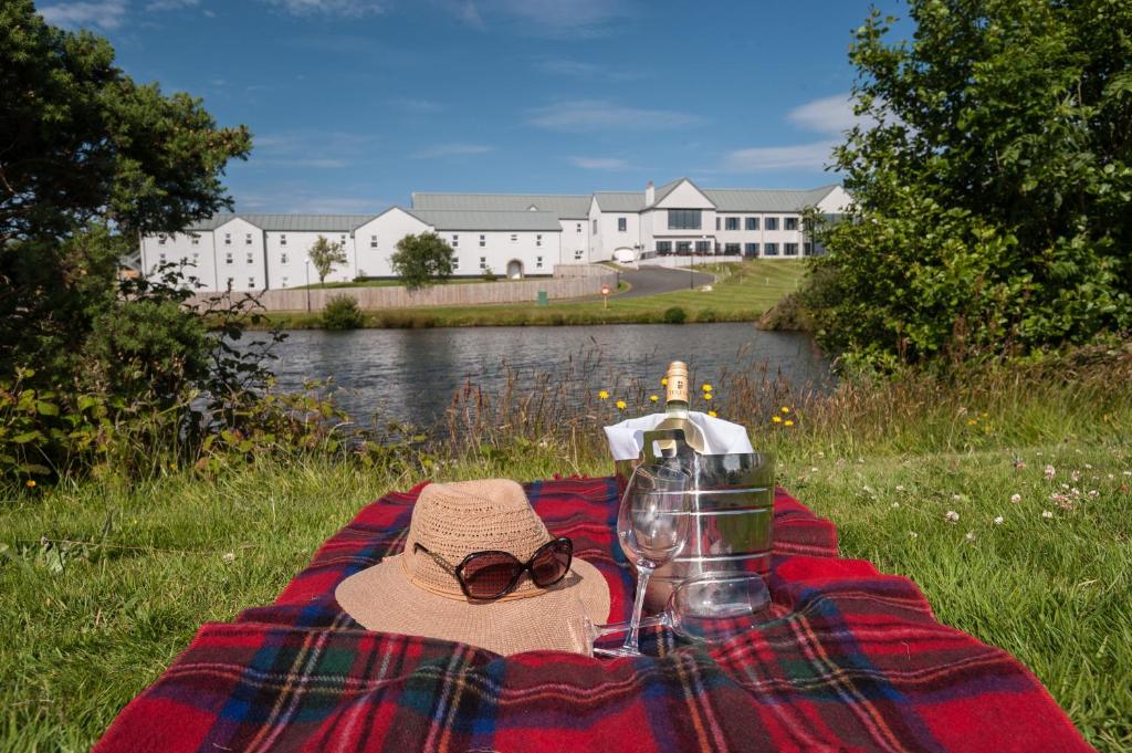 a picnic blanket with a hat and glasses on a table at Comis Hotel & Golf Resort in Douglas