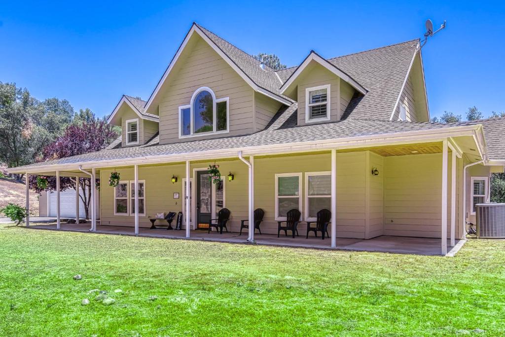 a house with a large front porch with chairs at Wooded Bliss in Mariposa