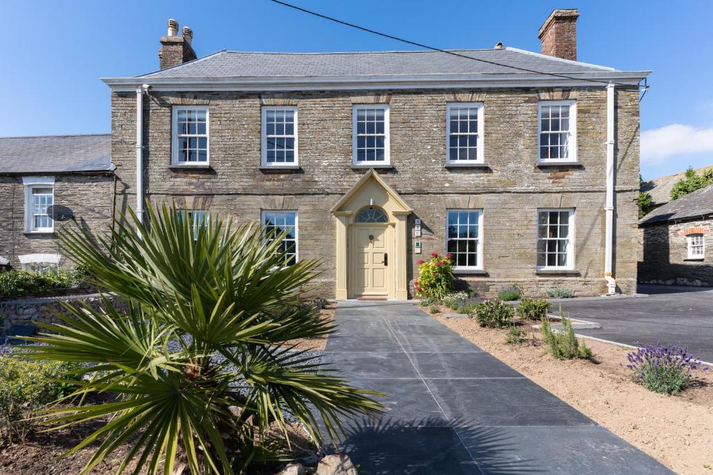 una vieja casa de ladrillo con una puerta amarilla en Finest Retreats - ARC Padstow, en Little Petherick