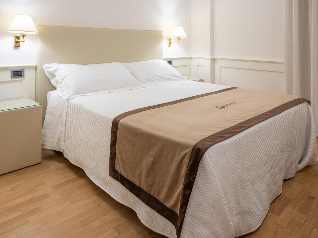 a bedroom with a large bed with white sheets at Mirabella Hotel in Mirabella Eclano