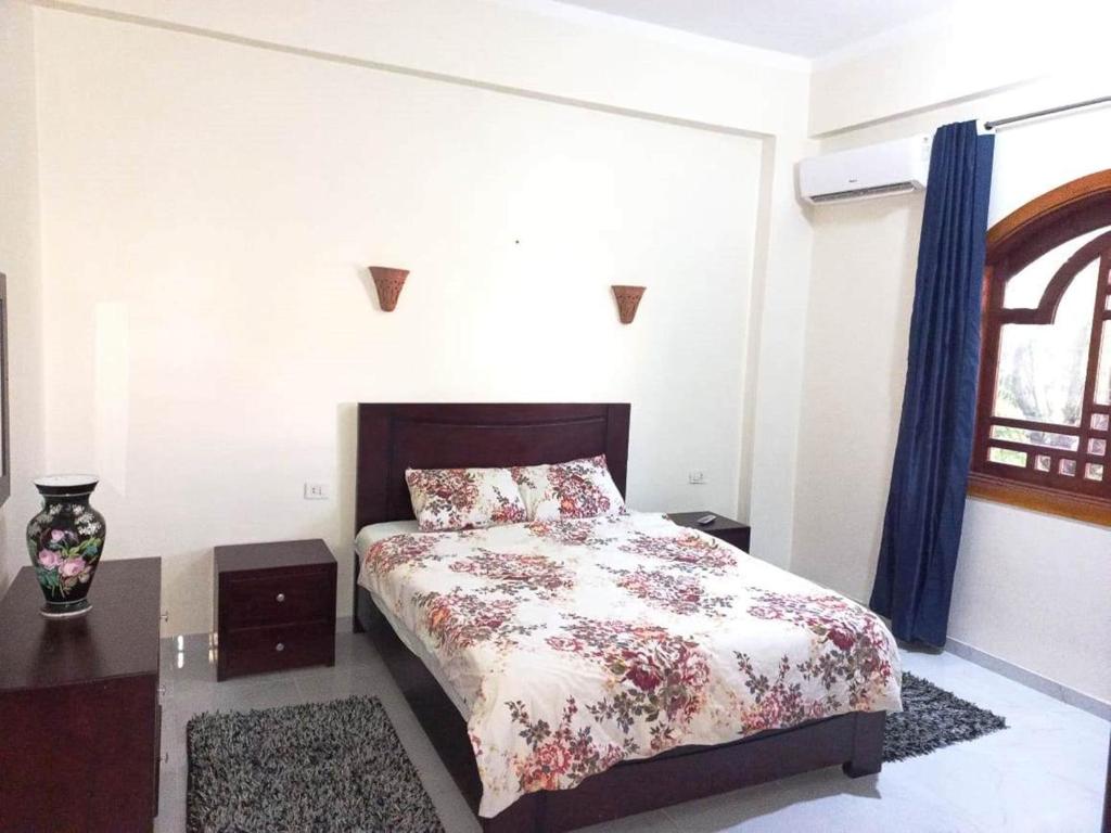 a bedroom with a bed with a floral bedspread at Villa Victoria Old Nile View in Luxor