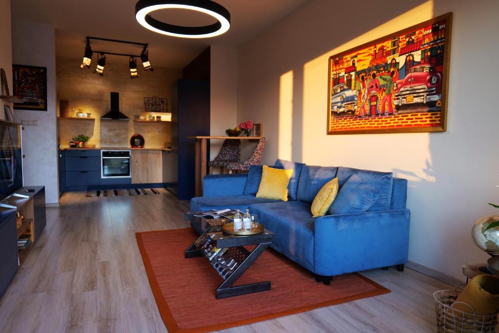 a living room with a blue couch and a table at Apartmán - modern home in Bardejov