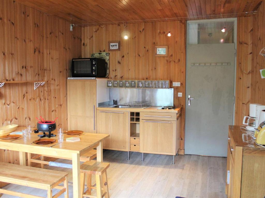 ヴァールにあるAppartement Vars, 1 pièce, 4 personnes - FR-1-330B-59の木製の壁、テーブル、電子レンジ付きのキッチン