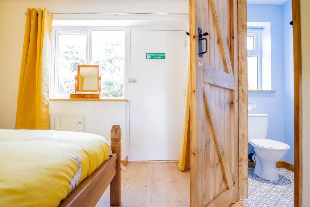 a bedroom with a bed and a wooden door at Muntjac View, Beechcroft Barns, Cawston, Norfolk in Norwich