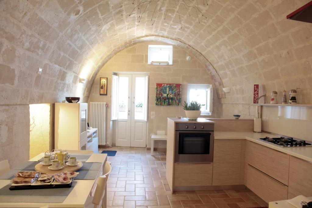 una cocina con un arco de piedra en una habitación en La Conchiglia Nei Sassi, en Matera