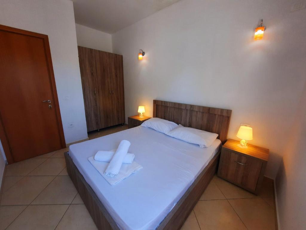 a bedroom with a bed with a cross on it at Apartments Alavana in Velipojë