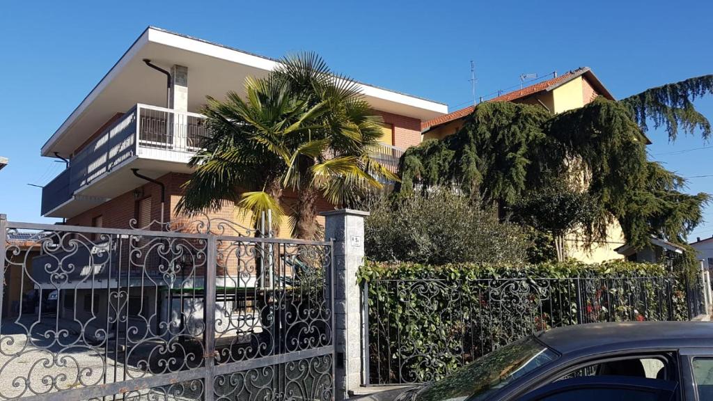 une maison avec une clôture et un palmier dans l'établissement Villa Signorina, à San Francesco al Campo