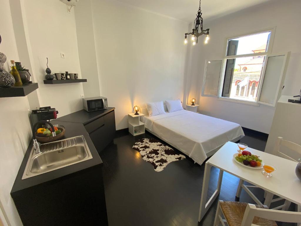 a small room with a bed and a kitchen with a sink at Artelie apartment in Kyparissia