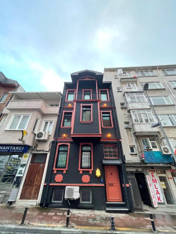 ein hohes Gebäude mit roten Türen an einer Stadtstraße in der Unterkunft Black Mansion in Istanbul