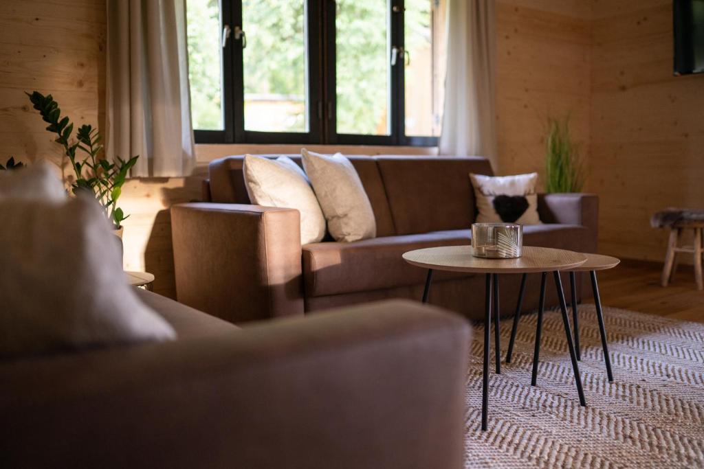 a living room with a couch and a table at Hüttenresort Mare in Fichtelberg