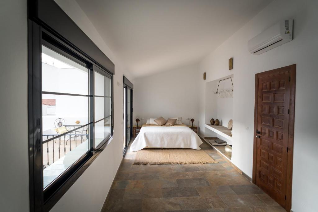 sypialnia z łóżkiem i dużym oknem w obiekcie Suites del Mundo w mieście Alhaurín el Grande