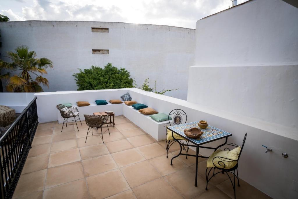 patio z krzesłami i kanapą na białej ścianie w obiekcie Suites del Mundo w mieście Alhaurín el Grande