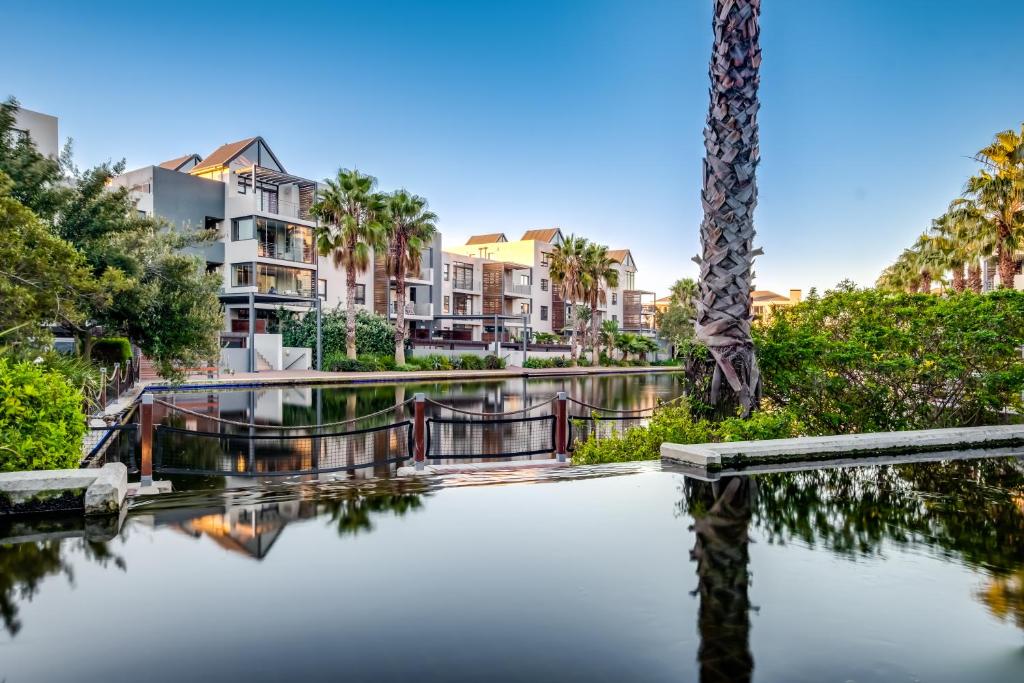 ケープタウンにあるQuayside Canal Eden Homeのヤシの木や建物のある水