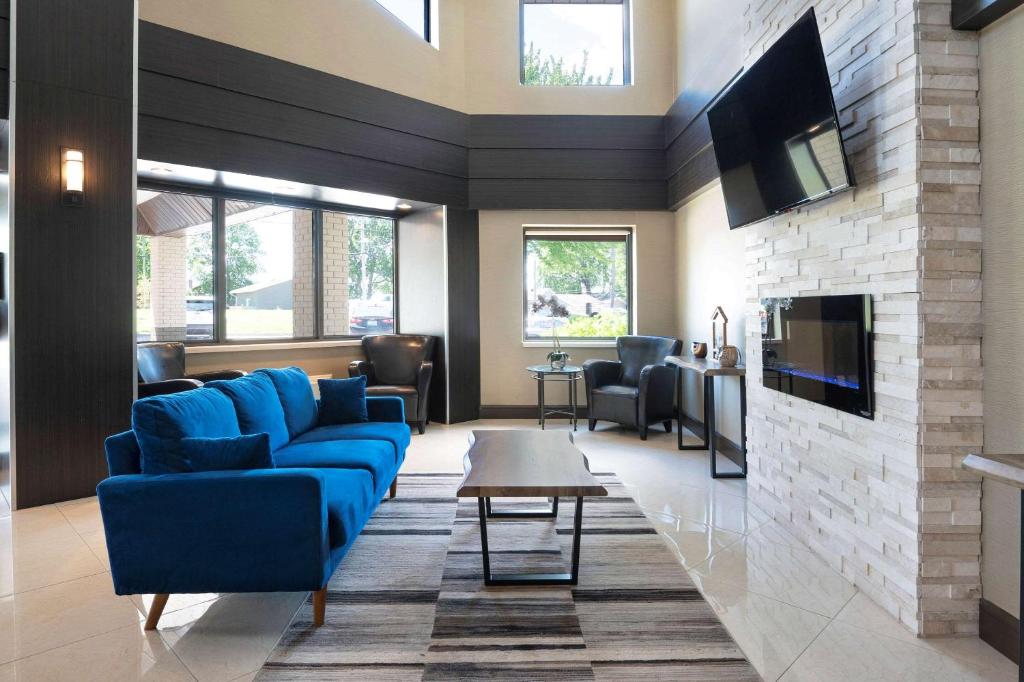 sala de estar con sofás azules y chimenea en Comfort Inn Lakeshore, en North Bay