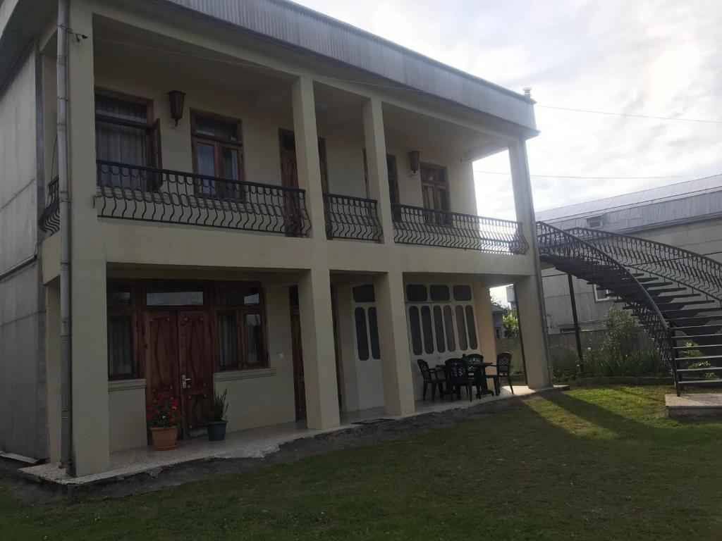 una casa con una escalera delante de ella en Luka Family Guest House en Batumi