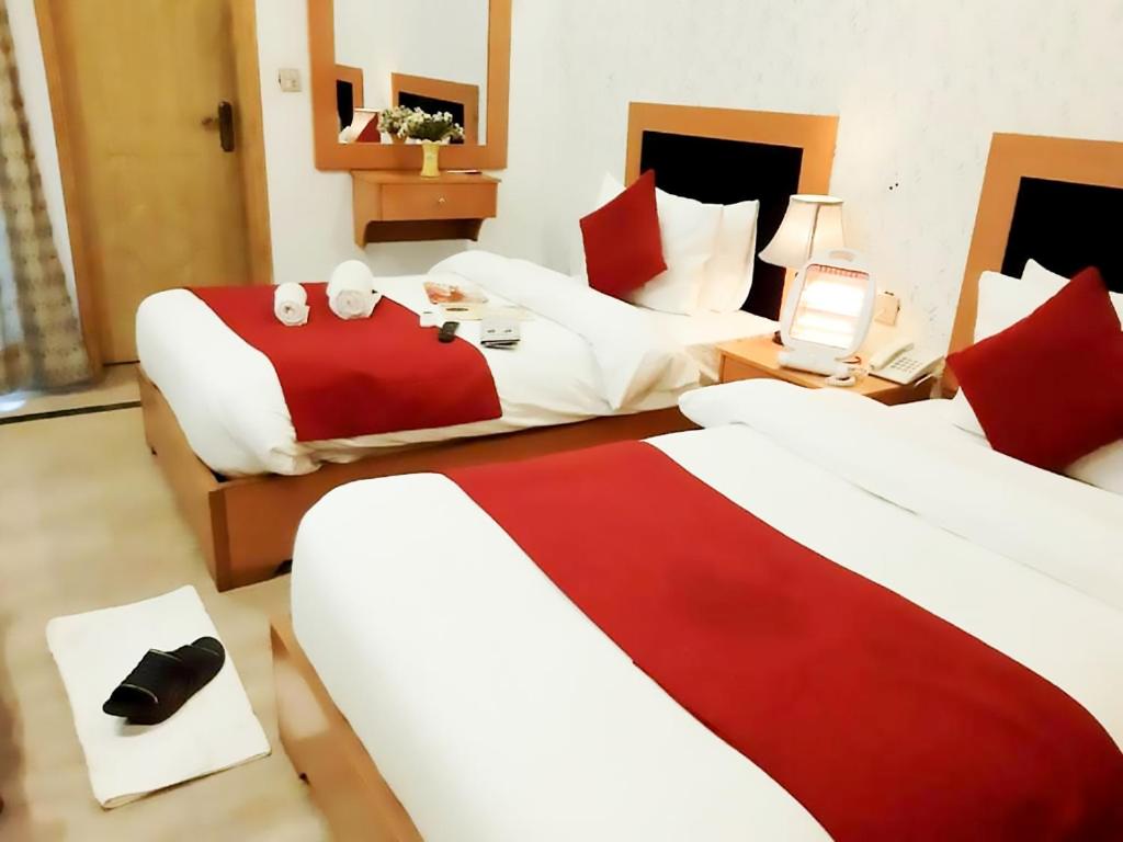 ein Hotelzimmer mit 2 Betten in Rot und Weiß in der Unterkunft Royal Continental Hotel in Lahore