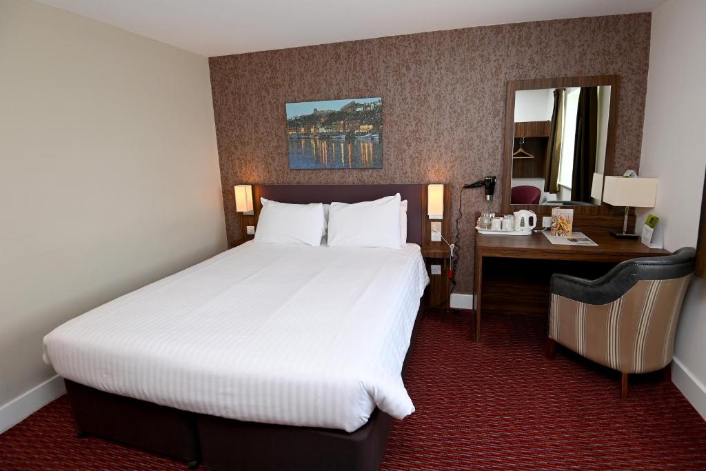 a hotel room with a large bed and a desk at Penny Hedge, Whitby by Marston's Inns in Whitby