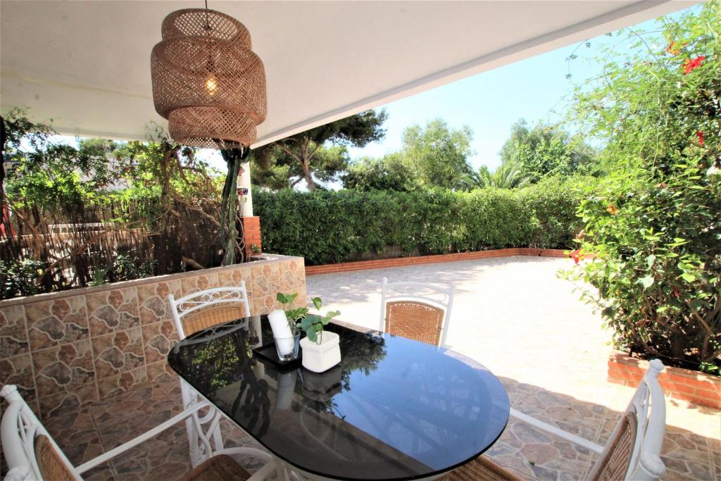 洪達海灘的住宿－Adosado La Salada by Rental Olé，一个带桌椅的庭院和一个游泳池
