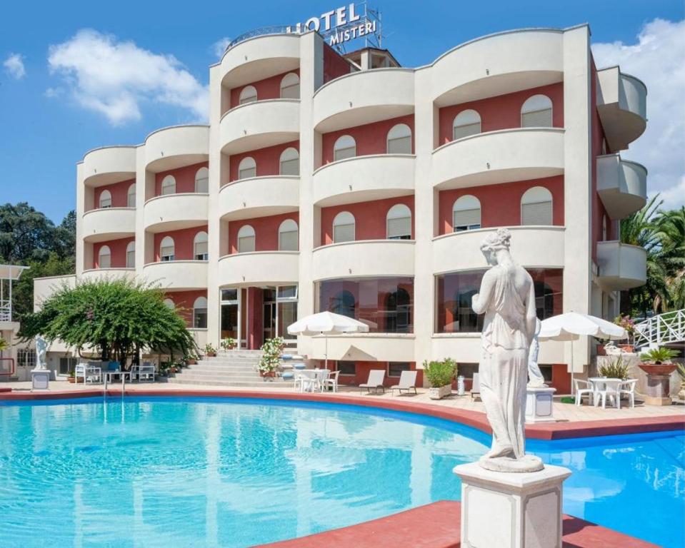 un hôtel avec une piscine en face d'un bâtiment dans l'établissement Villa Dei Misteri, à Pompéi