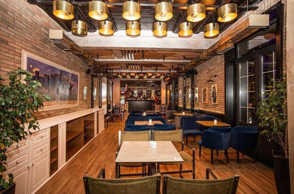 um restaurante com mesas e cadeiras e um bar em Primo Hotel em Tirana
