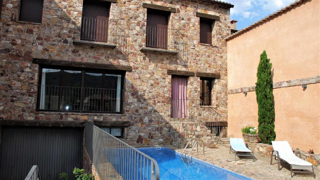 un edificio con piscina frente a un edificio en Casa de lujo en el Parque Nacional de Cabañeros, en Navas de Estena