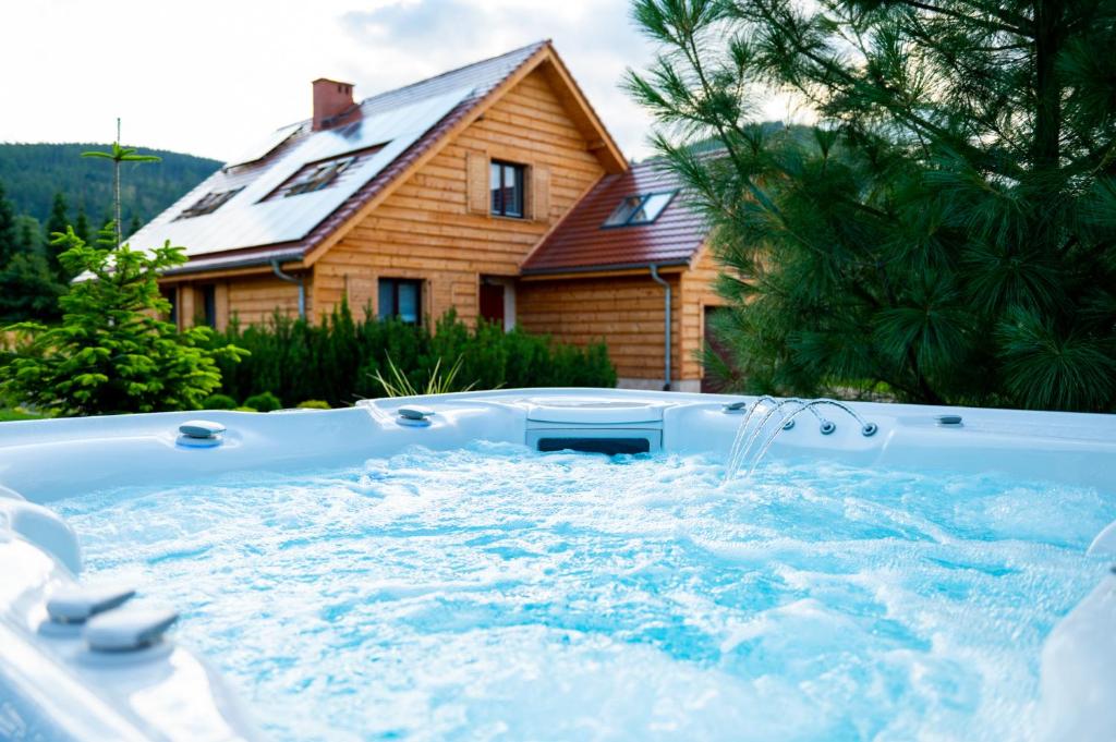 a jacuzzi tub in front of a house at Karkonoski Klimat - apartamenty z sauną, balią i jacuzzi in Miłków