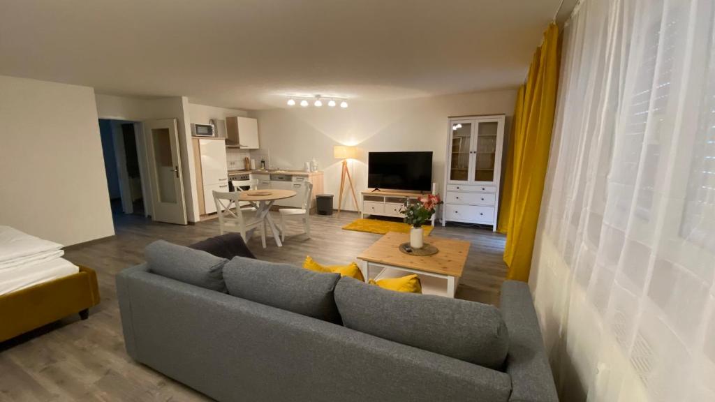 - un salon avec un canapé gris et une table dans l'établissement City-Appartement 12.4., à Zwickau