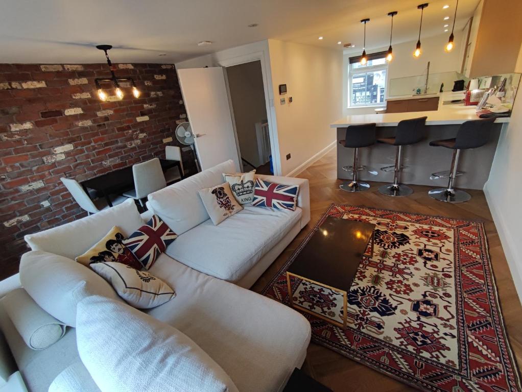 a living room with a white couch and a bar at Modern 2 Bedroom Flat with private outdoor terrace in London