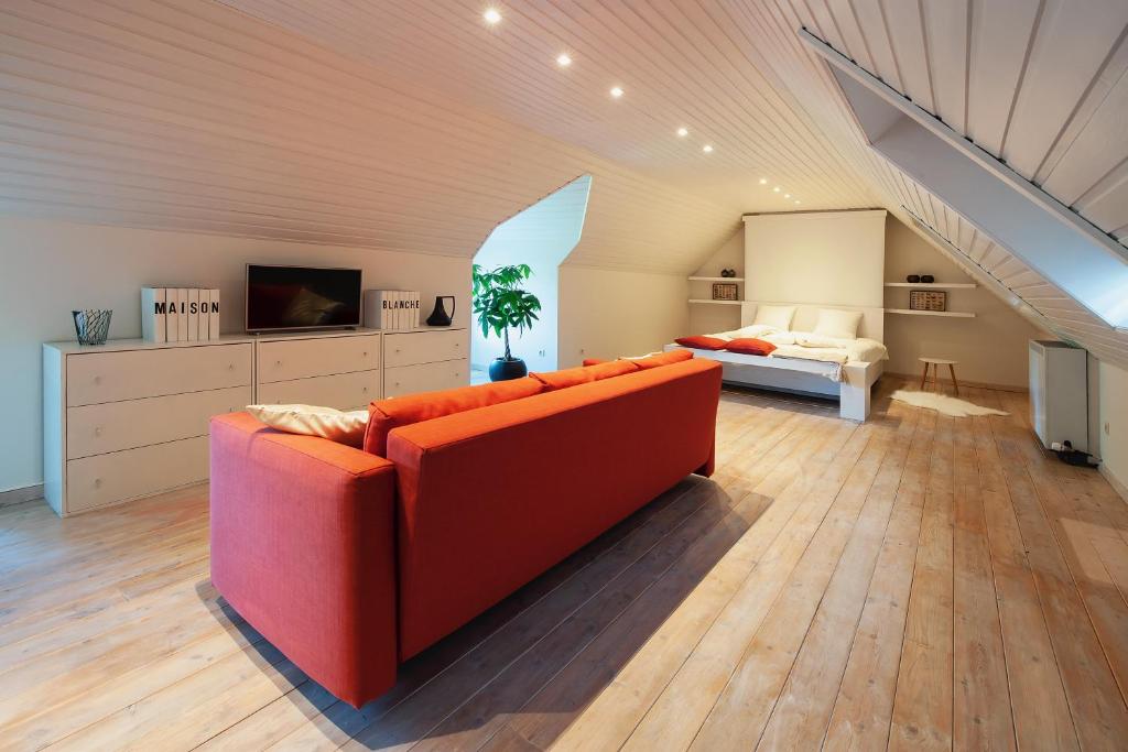 salon z czerwoną kanapą i łóżkiem w obiekcie B&B Maison Blanche w Gandawie