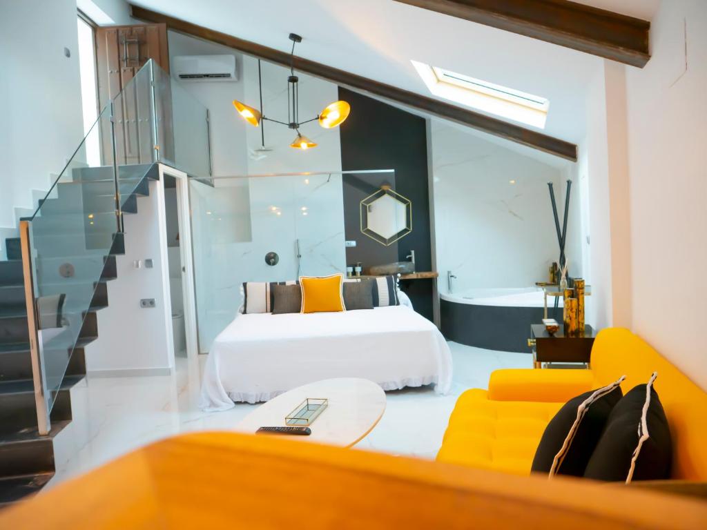 アルカラ・デル・フカルにあるComplejo Casa Carmen Alcalá Del Júcarのベッドルーム(白いベッド1台、黄色のソファ付)