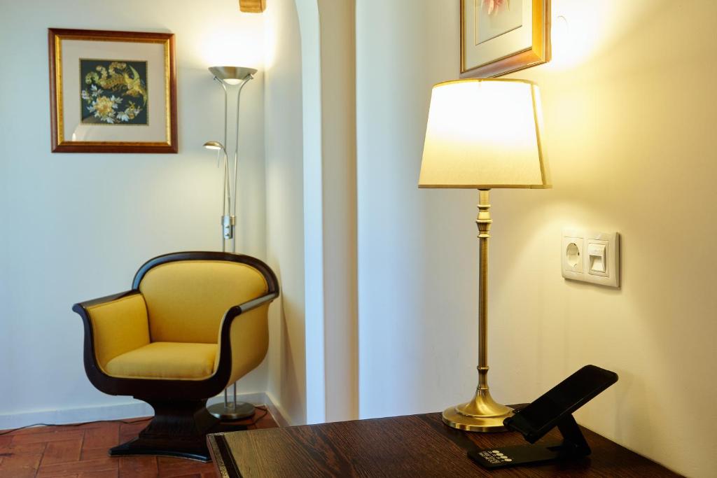 a room with a chair and a lamp on a table at Hotel Fortaleza do Guincho Relais & Châteaux in Cascais