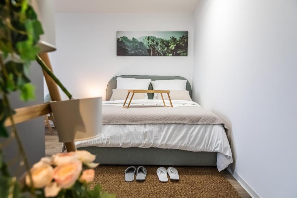 a bedroom with a bed and two pairs of shoes at Modern Studio good located Balcony King Bed in Frankfurt