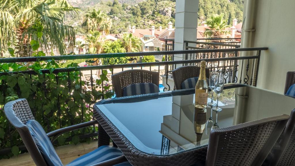a table and chairs on a balcony with a bottle of wine at dolphine apatment turunç in Marmaris