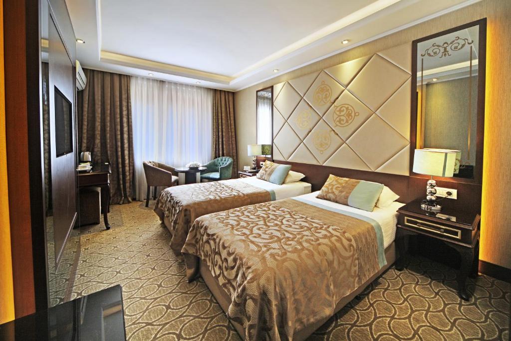 Cette chambre comprend 2 lits et un miroir. dans l'établissement The Parma Hotel Downtown, à Istanbul