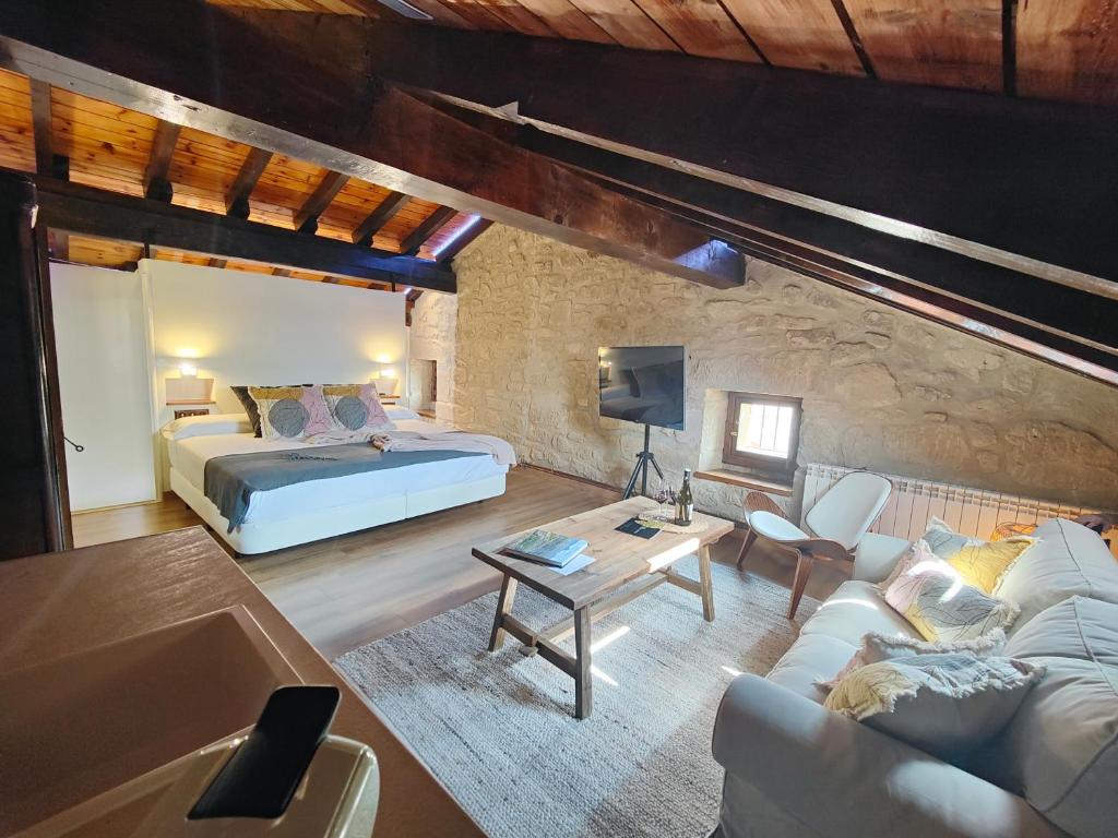 a bedroom with a bed and a living room at Casa Rural La Molinera Etxea in Samaniego