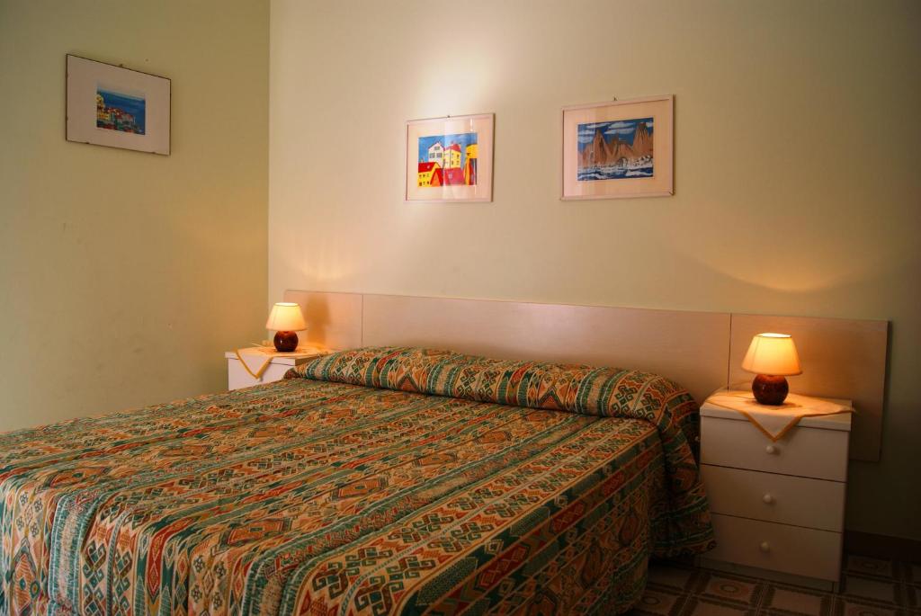Habitación de hotel con 1 cama y 2 lámparas en La terrazza tra pini e mare, en San Bartolomeo al Mare