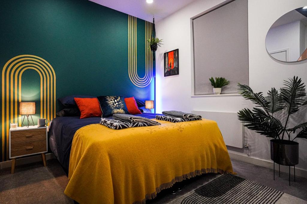 a bedroom with a bed with a yellow blanket at Luxury Stevenage Town Centre Apartment in Stevenage