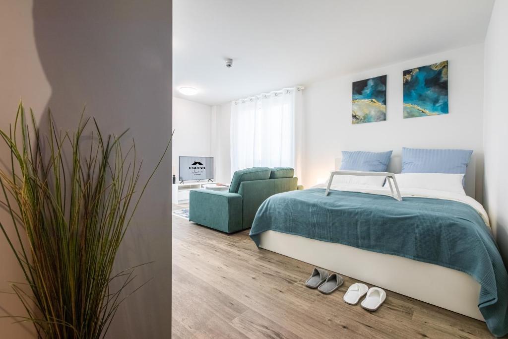 a bedroom with a bed and a green chair at Modern Studio and good located in Frankfurt/Main