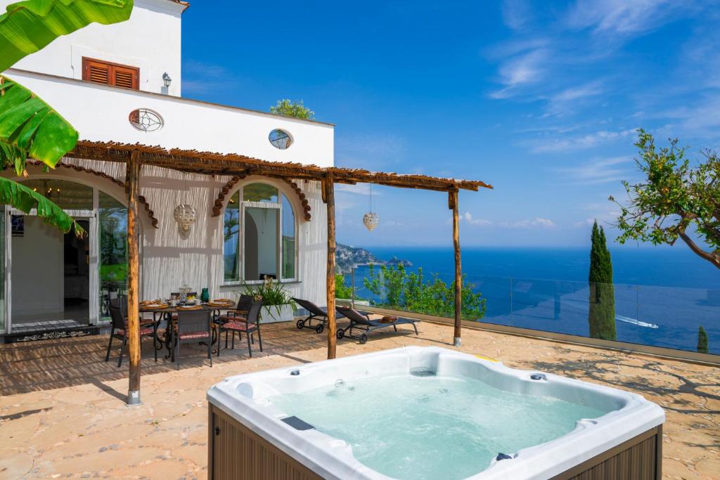 a hot tub on the patio of a house at Villa Mimina - Exclusive villa with garden, Jacuzzi and sea view in Praiano