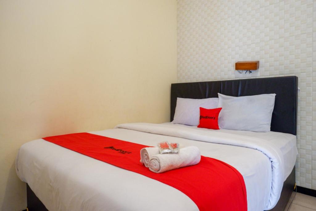 a bed with two towels sitting on top of it at RedDoorz At Hotel Sartika Yogyakarta in Yogyakarta
