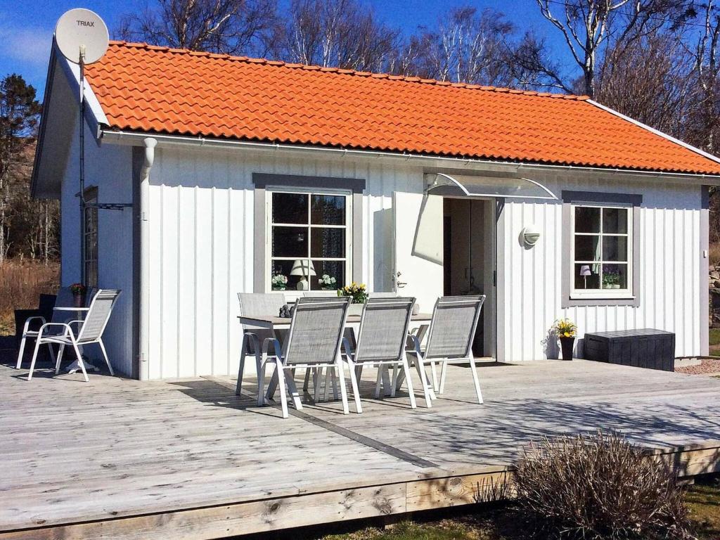 リューセヒールにある4 person holiday home in LYSEKILのオレンジ色の屋根のデッキ(テーブル、椅子付)